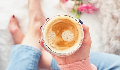 Mujer sujetando una taza de café con leche